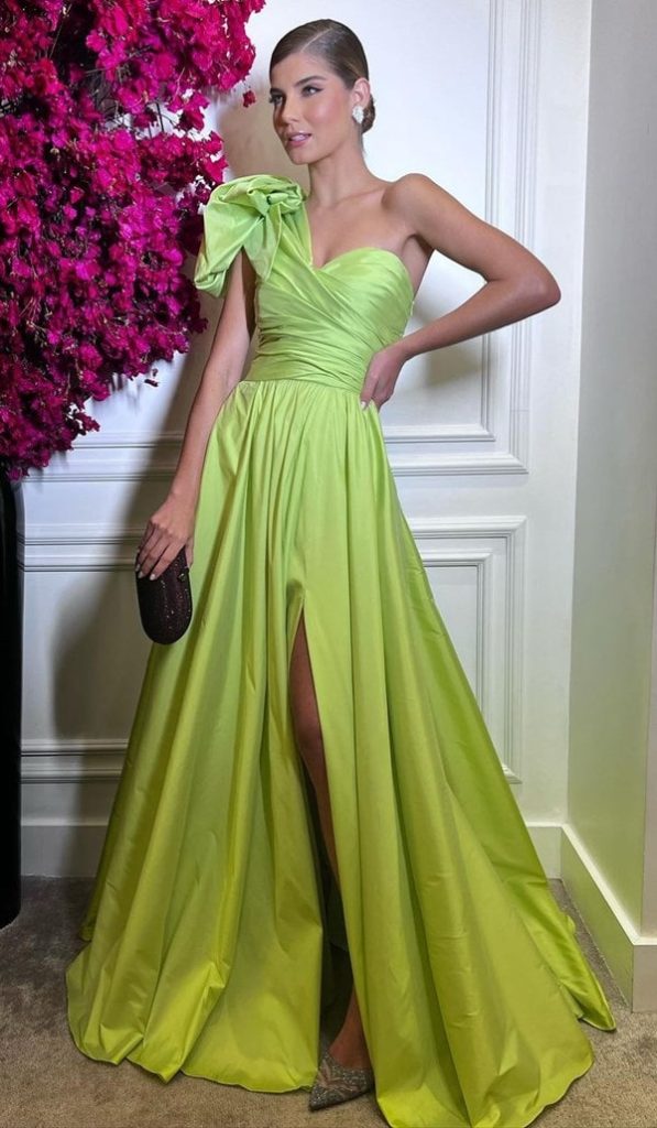 vestido de festa longo verde lima com saia ampla com fenda, modelo um ombro só com flor bordada na alça